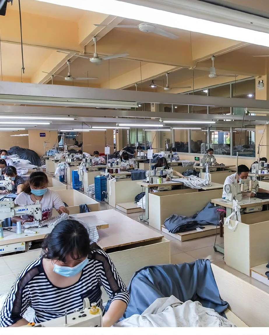 Operators sewing textile products in a working production area